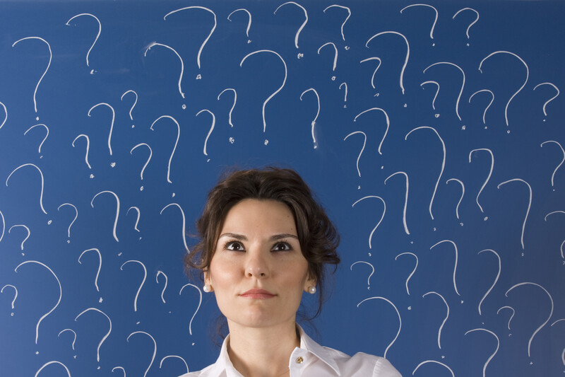 thinking about divorce: woman in front of blue background surrounded by question marks